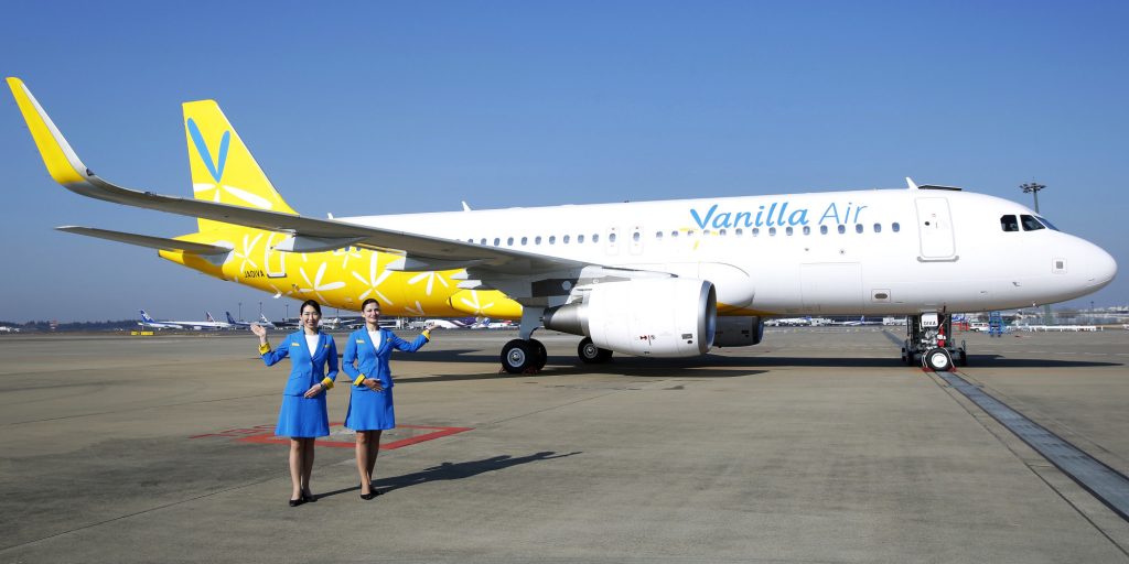 Cabin attendants pose for a photograph in front of a Vanilla Air Airbus SAS A320 aircraft during a media preview at Narita Airport in Narita, Chiba Prefecture, Japan, on Tuesday, Dec. 3, 2013. ANA Holdings Inc. rebranded its low-cost carrier as Vanilla Air after a venture with Sepang, Malaysia-based AirAsia Bhd. dissolved in June over disagreements on how to run the company. Photographer: Kiyoshi Ota/Bloomberg via Getty Images